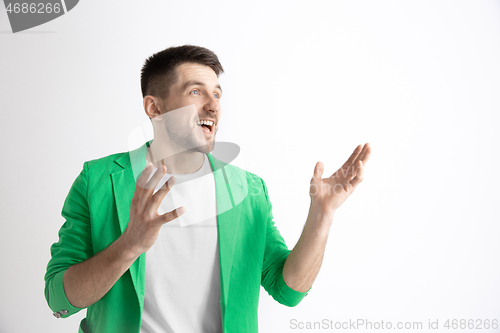 Image of The happy businessman standing and smiling against gray background.