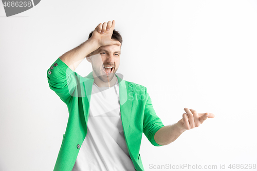 Image of Losers go home. Portrait of happy guy showing loser sign over forehead