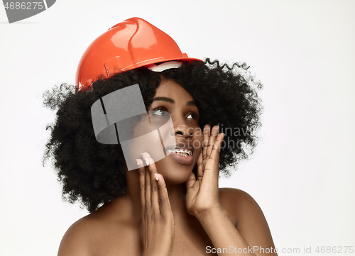 Image of Portrait of confident female worker in orange helmet