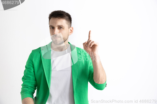 Image of The happy businessman standing and smiling against gray background.