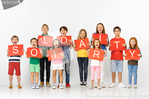 Image of Solidarity. Group of children with a red banners isolated in white