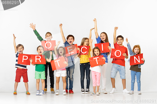 Image of Protection. Group of children with a red banners isolated in white