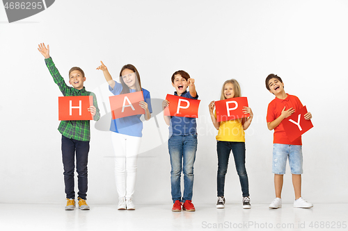 Image of Happy. Group of children with red banners isolated in white