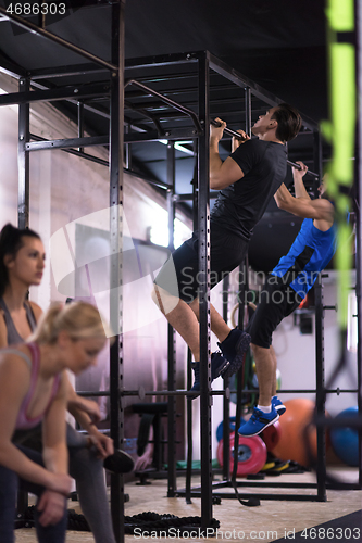 Image of young athletes doing pull ups on the horizontal bar