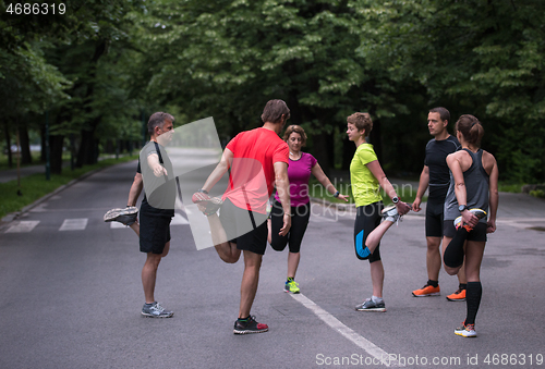 Image of runners team warming up and stretching before morning training