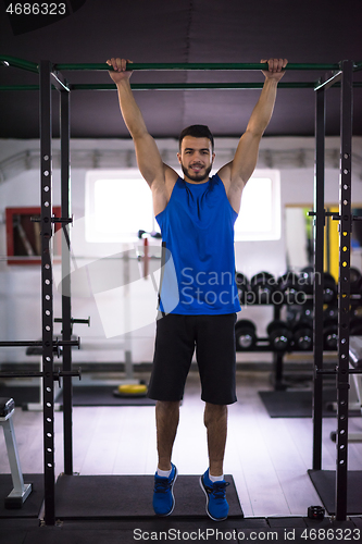 Image of man doing pull ups on the horizontal bar