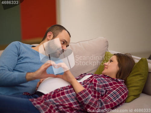 Image of man and pregnant woman showing heart sign