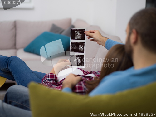 Image of pregnant couple looking baby\'s ultrasound