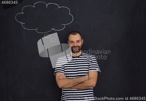 Image of young future father thinking in front of black chalkboard