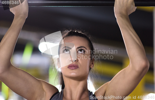 Image of woman doing pull ups on the horizontal bar