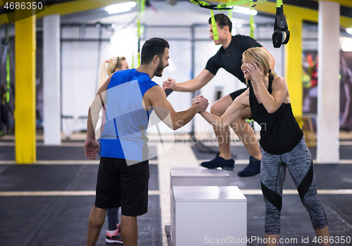 Image of athletes working out  jumping on fit box