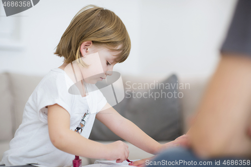 Image of daughter painting nails to her pregnant mom