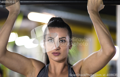 Image of woman doing pull ups on the horizontal bar