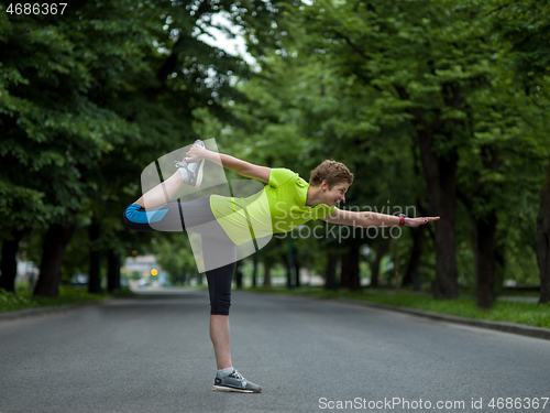 Image of female runner warming up and stretching before morning training