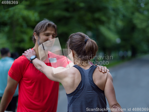 Image of runners team warming up and stretching before morning training