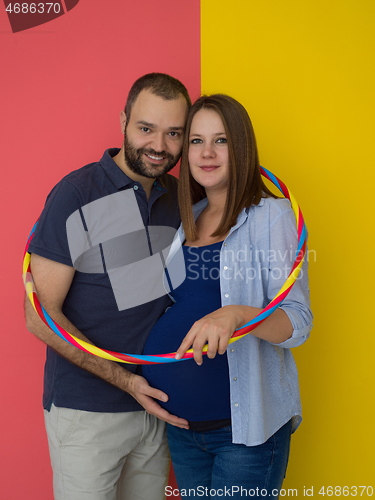 Image of pregnant couple  isolated over colorful background