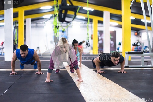 Image of young healthy people doing pushups