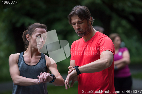 Image of sporty couple using smart watches