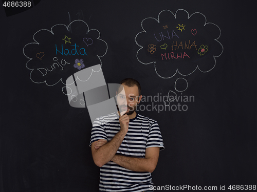 Image of young future father thinking in front of black chalkboard