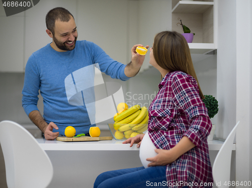 Image of couple cooking food fruit lemon juice at kitchen