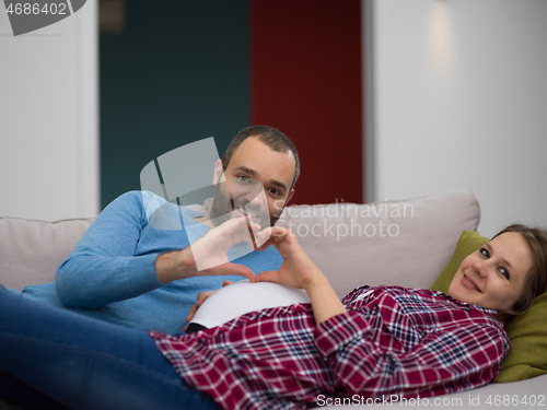 Image of man and pregnant woman showing heart sign