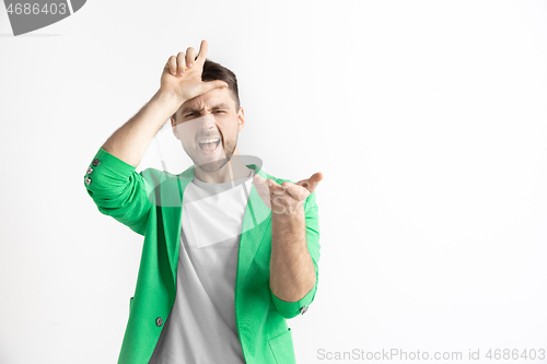 Image of Losers go home. Portrait of happy guy showing loser sign over forehead