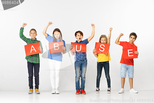 Image of Abuse. Group of children with red banners isolated in white