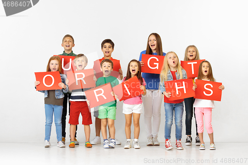 Image of Our rights. Group of children with red banners isolated in white