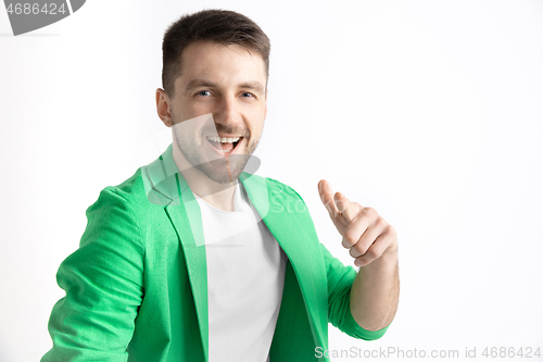 Image of The happy businessman standing and smiling against gray background.