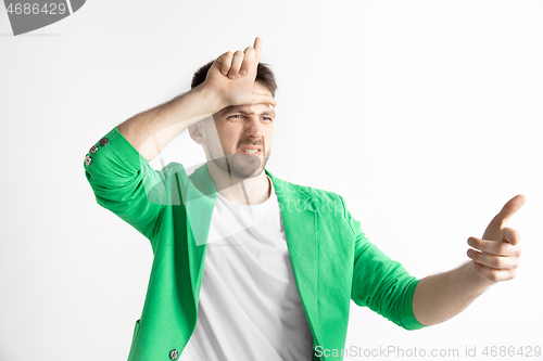 Image of Losers go home. Portrait of happy guy showing loser sign over forehead