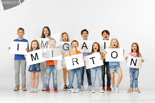 Image of Immigration. Group of children with a banners isolated in white