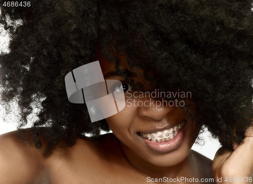 Image of Portrait of a young black woman smiling with braces