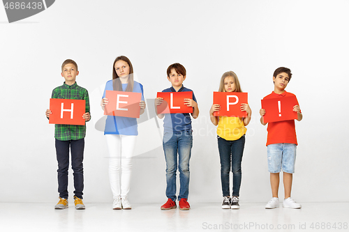 Image of Help. Group of children with red banners isolated in white