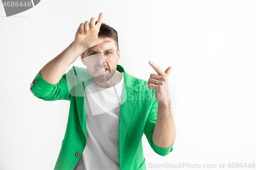 Image of Losers go home. Portrait of happy guy showing loser sign over forehead