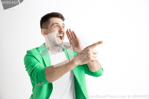 Image of The happy businessman standing and smiling against gray background.