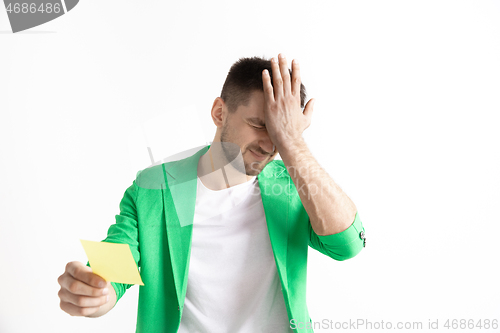 Image of Young boy with a surprised unhappy failure expression bet slip on studio background.