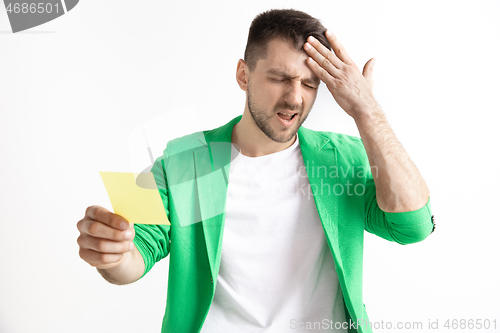 Image of Young boy with a surprised unhappy failure expression bet slip on studio background.