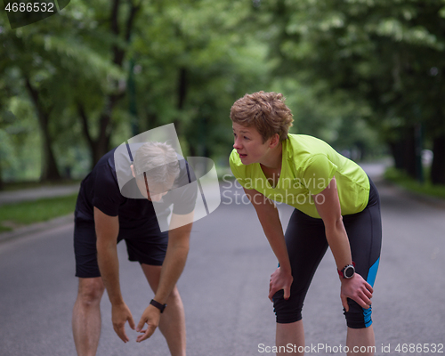 Image of runners team warming up and stretching before morning training