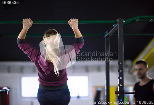 Image of woman doing pull ups on the horizontal bar