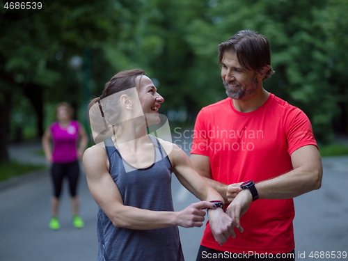 Image of sporty couple using smart watches