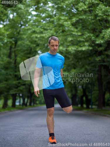 Image of male runner warming up and stretching before morning training