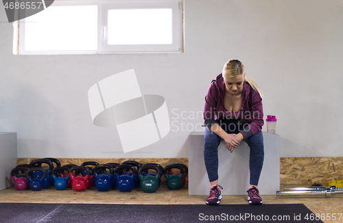 Image of young athlete woman sitting and relaxing