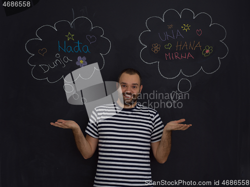 Image of young future father thinking in front of black chalkboard