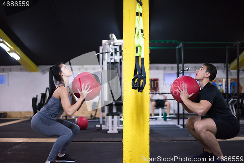 Image of young athletes couple working out with medical ball