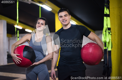 Image of young athletes couple working out with medical ball