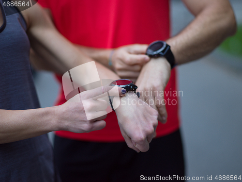 Image of sporty couple using smart watches