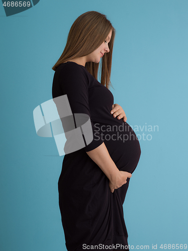 Image of Portrait of pregnant woman over blue background