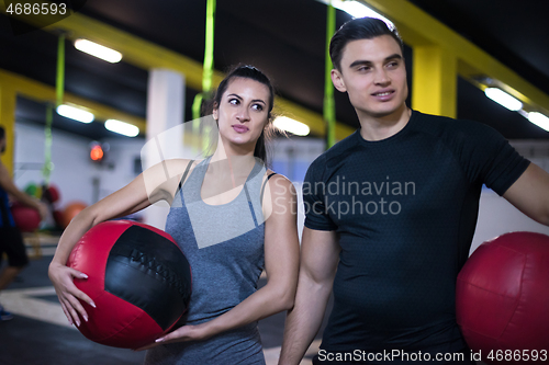 Image of young athletes couple working out with medical ball