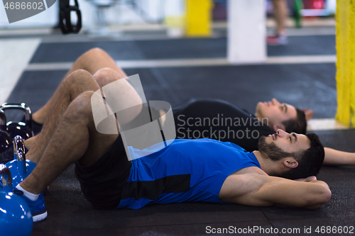 Image of young athletes lying on the floor and relaxing