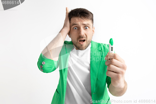 Image of Upset man looking in pregnancy test. Frustrated model